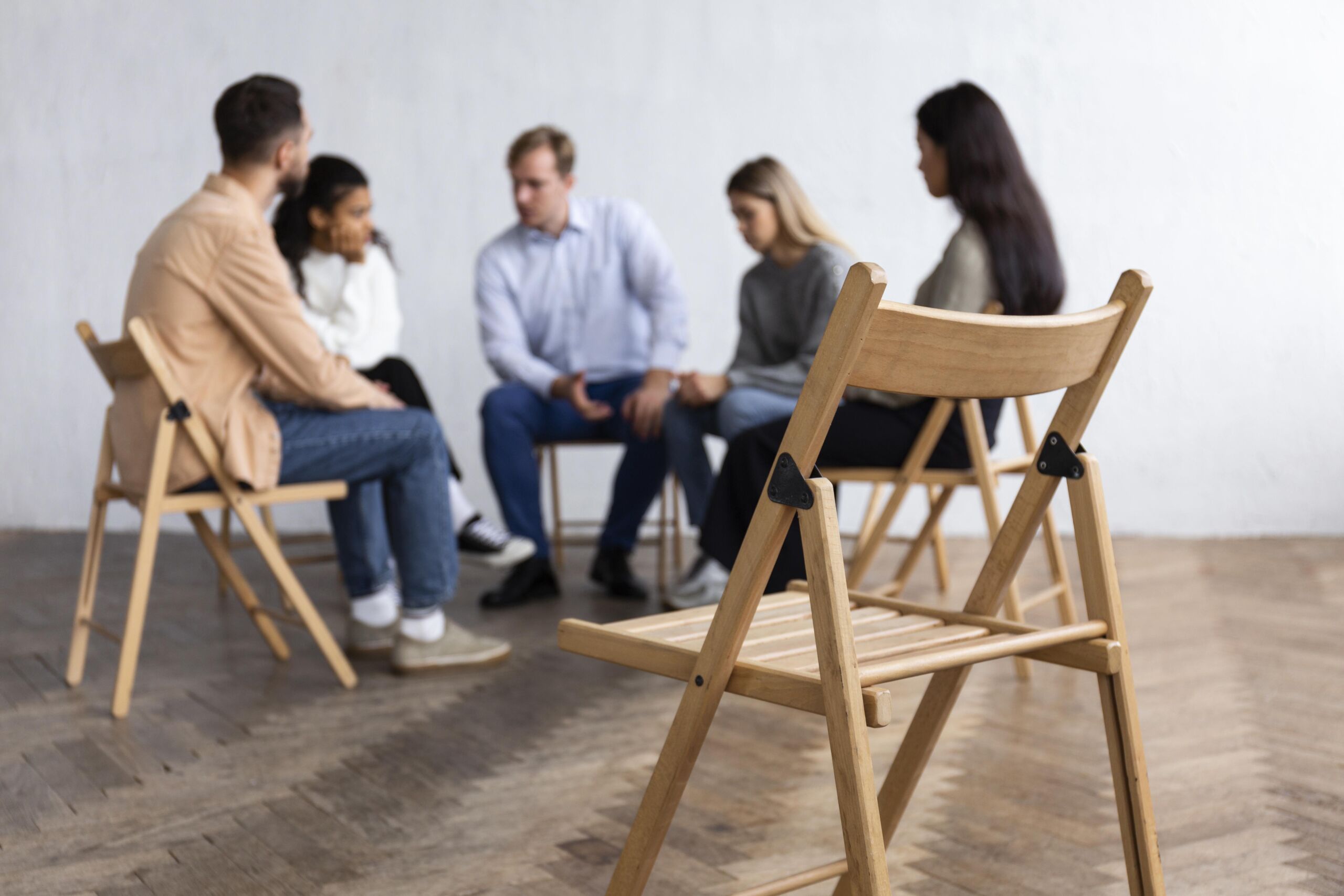 people sitting in a circle on chairs