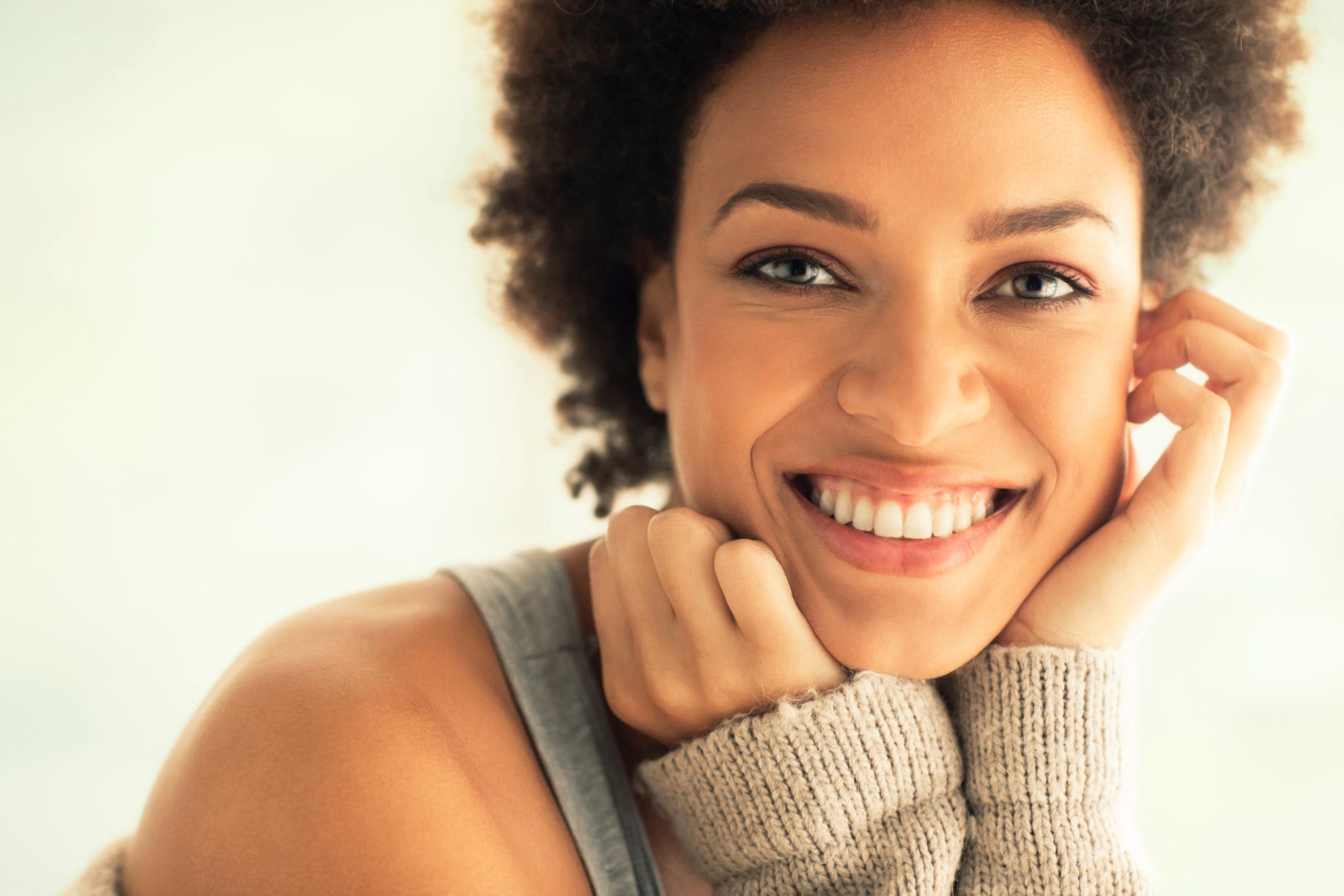 woman smiling with hands to face