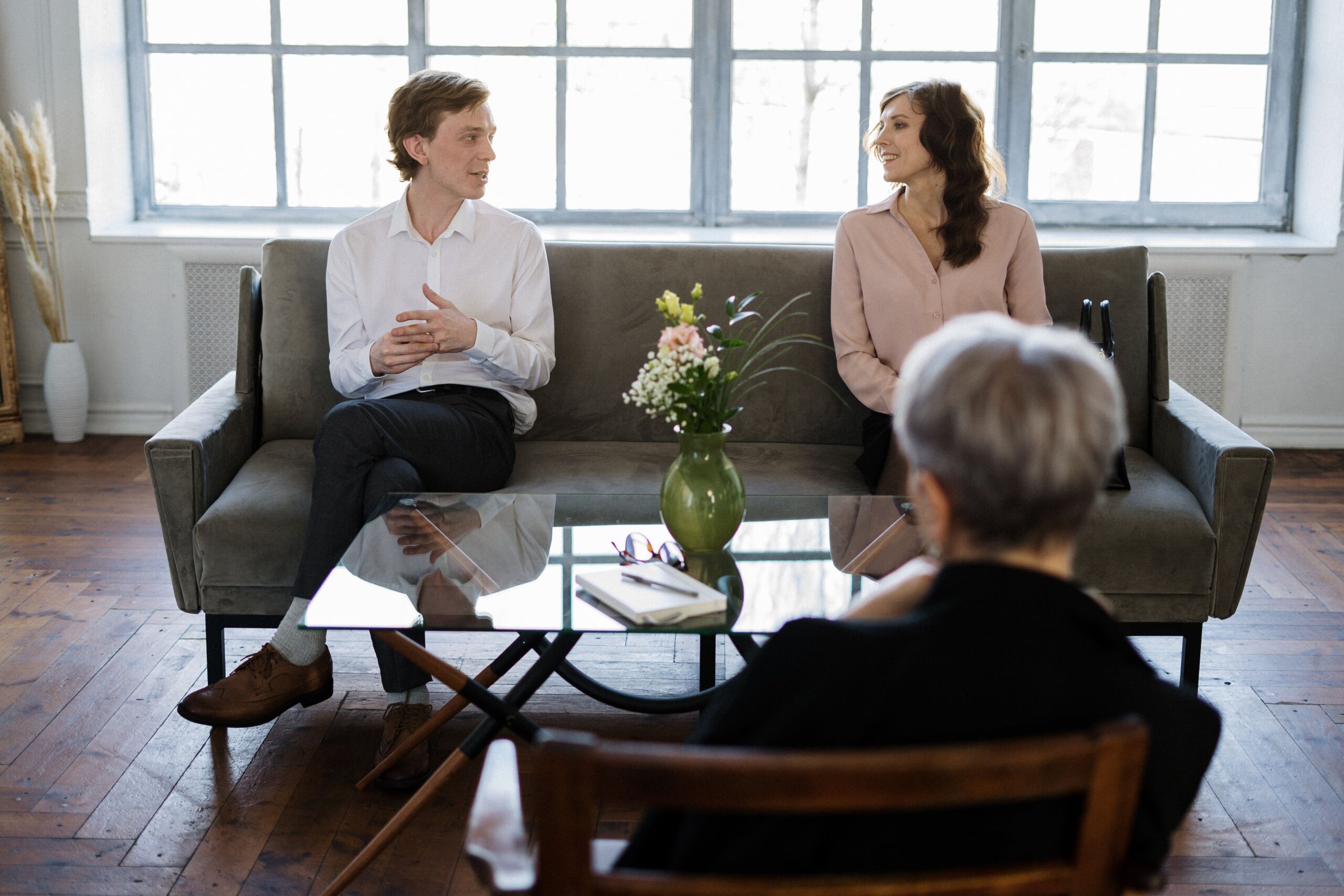 two people on couch sitting apart and looking at each other