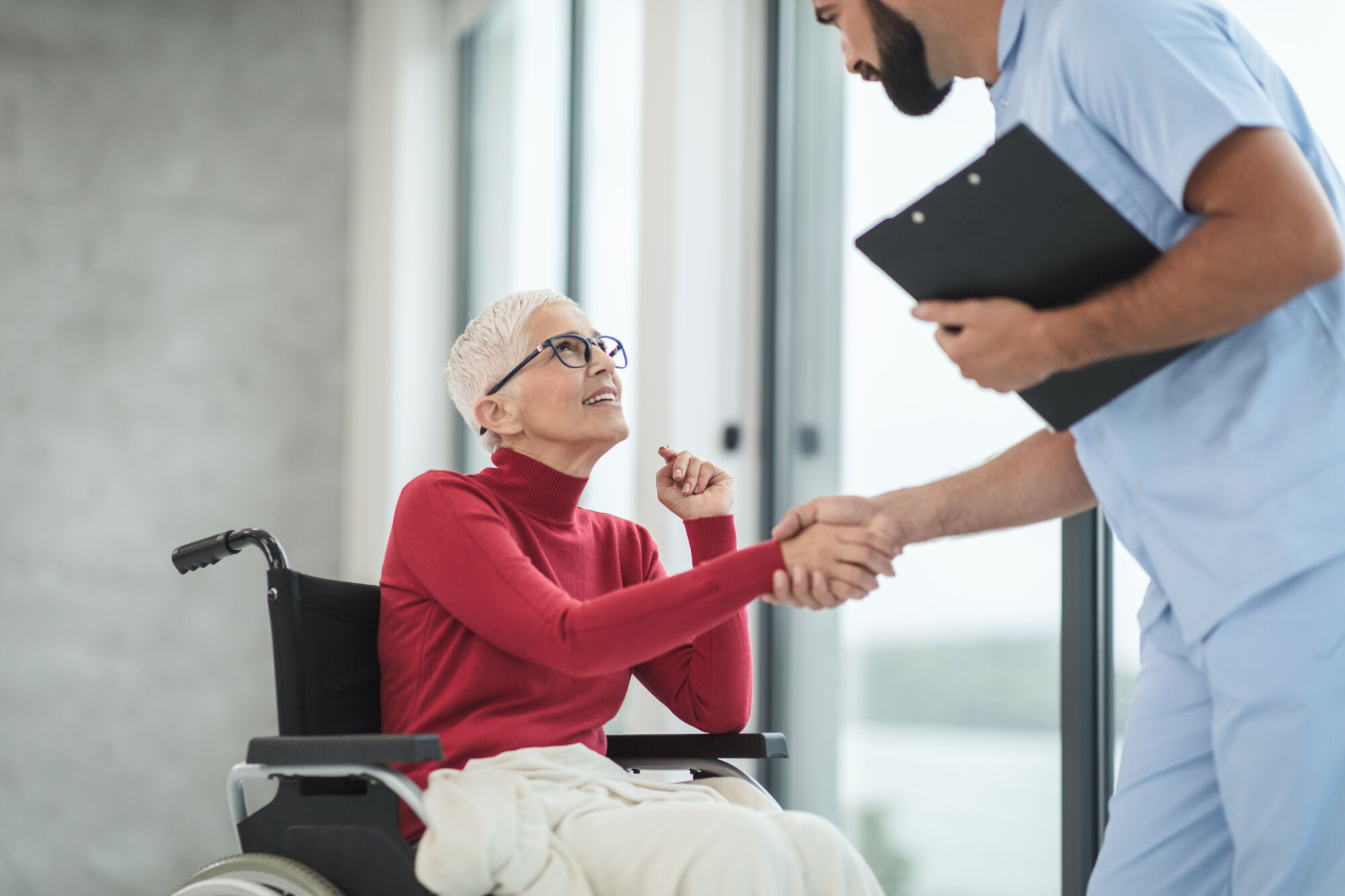 Nurse helping woman in wheelchair